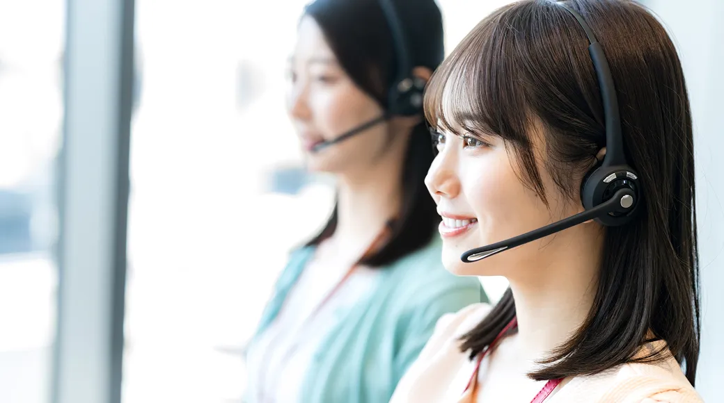 ヘッドセットをつけて対応するカスタマーサポートの女性