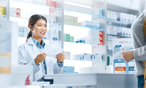 調剤薬局の女性が処方箋を持っている様子