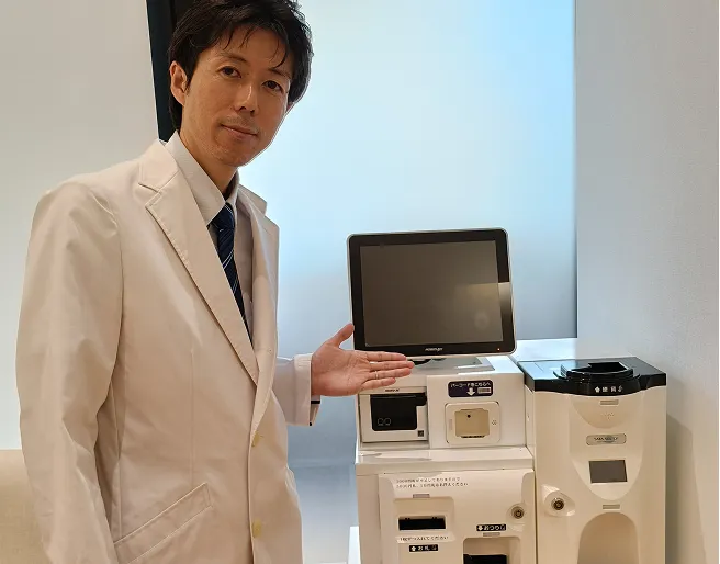 医師が導入された自動精算機を案内している様子