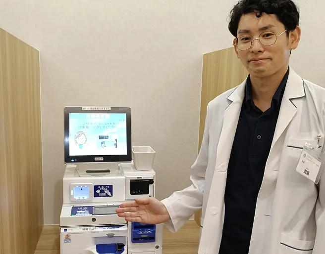 医師が導入された自動精算機を案内している様子