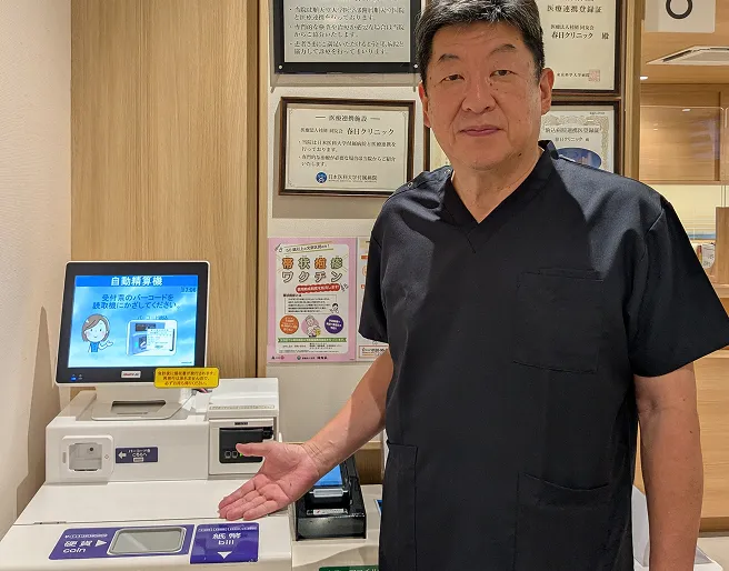 医師が導入された自動精算機を案内している様子