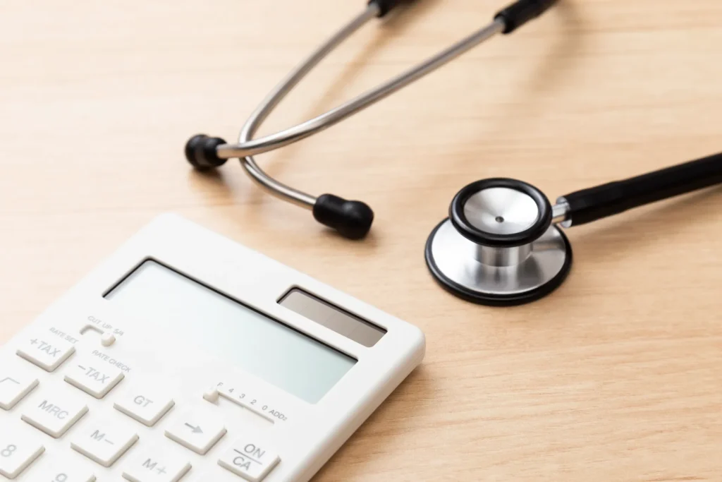 木の机に聴診器と電卓が置かれています
