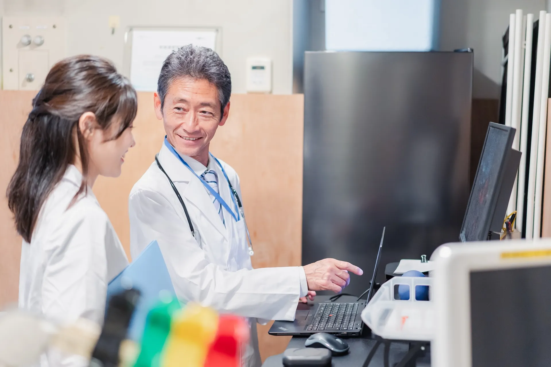 診療予約システムを確認しながら話す医師と看護師